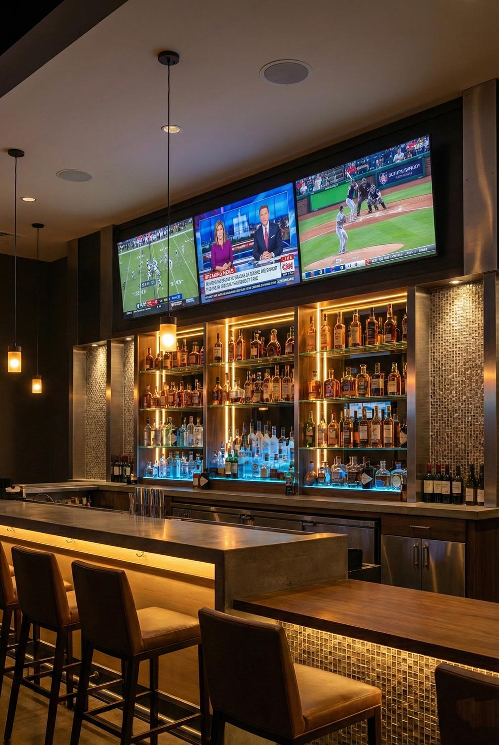 Bar with illuminated liquor shelves and three wall mounted screens