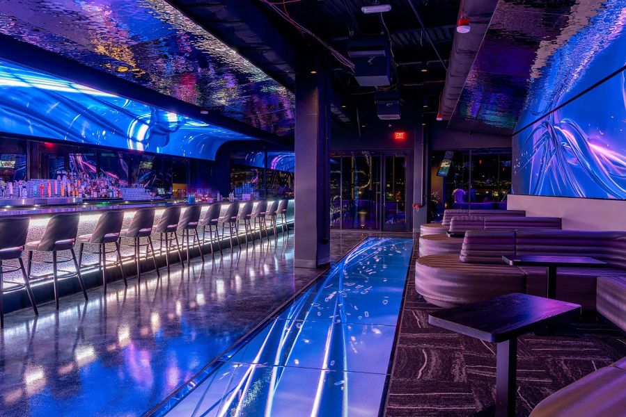 Sleek bar with glowing blue floor tiles and matching abstract wall displays