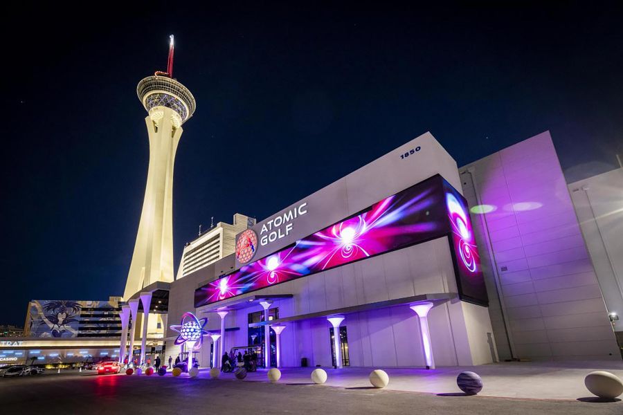 Modern building exterior with a large colorful digital screen at night