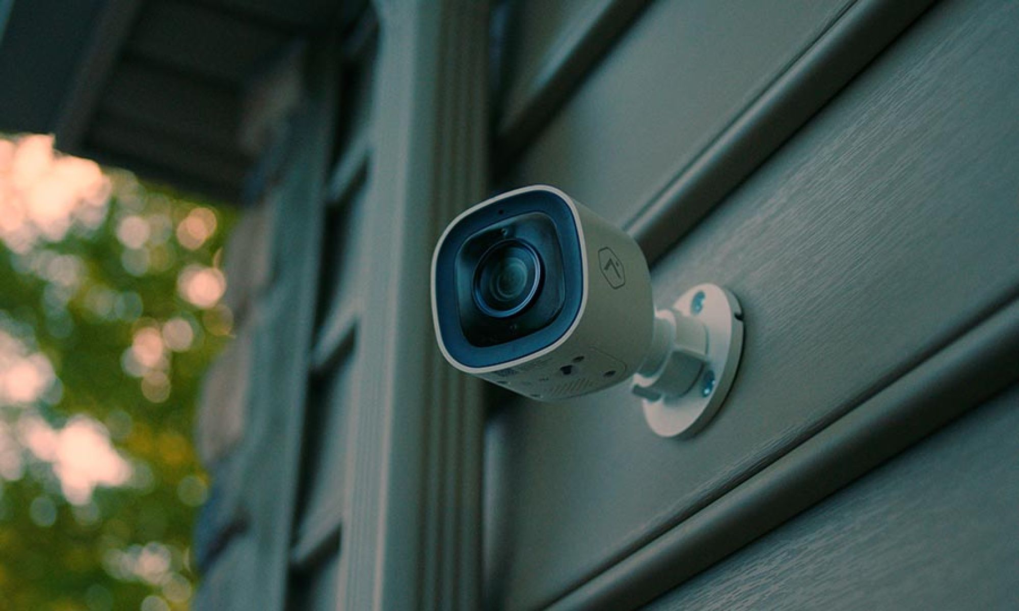 Outdoor security camera mounted on home exterior siding