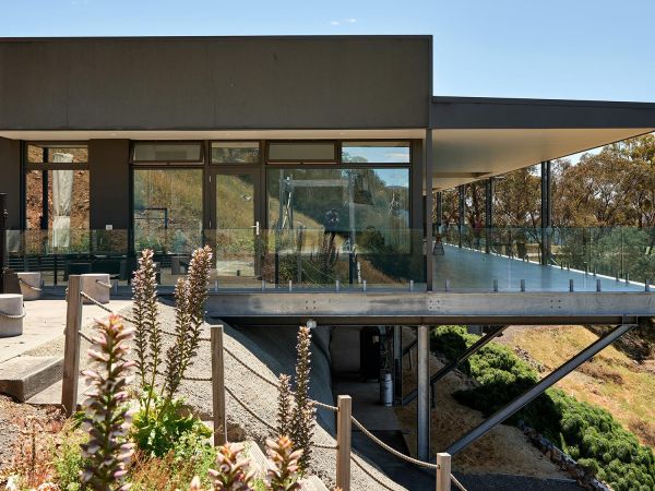 Contemporary two story home with large glass walls and warm interior lighting